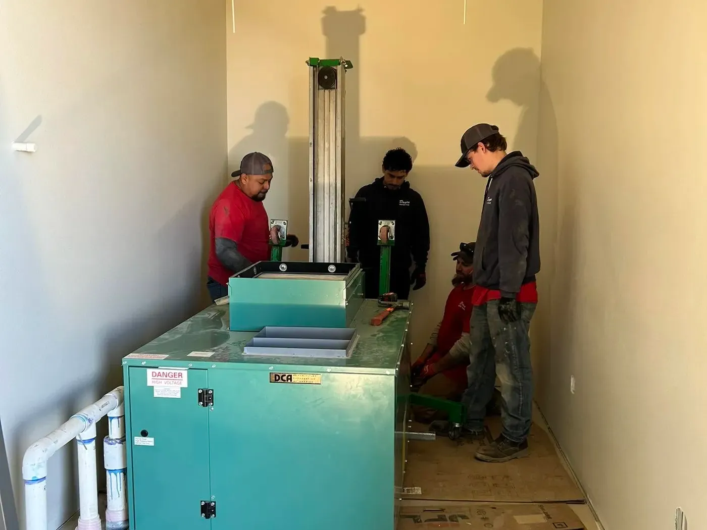 Dayco crew installing equipment in an unfinished commercial interior