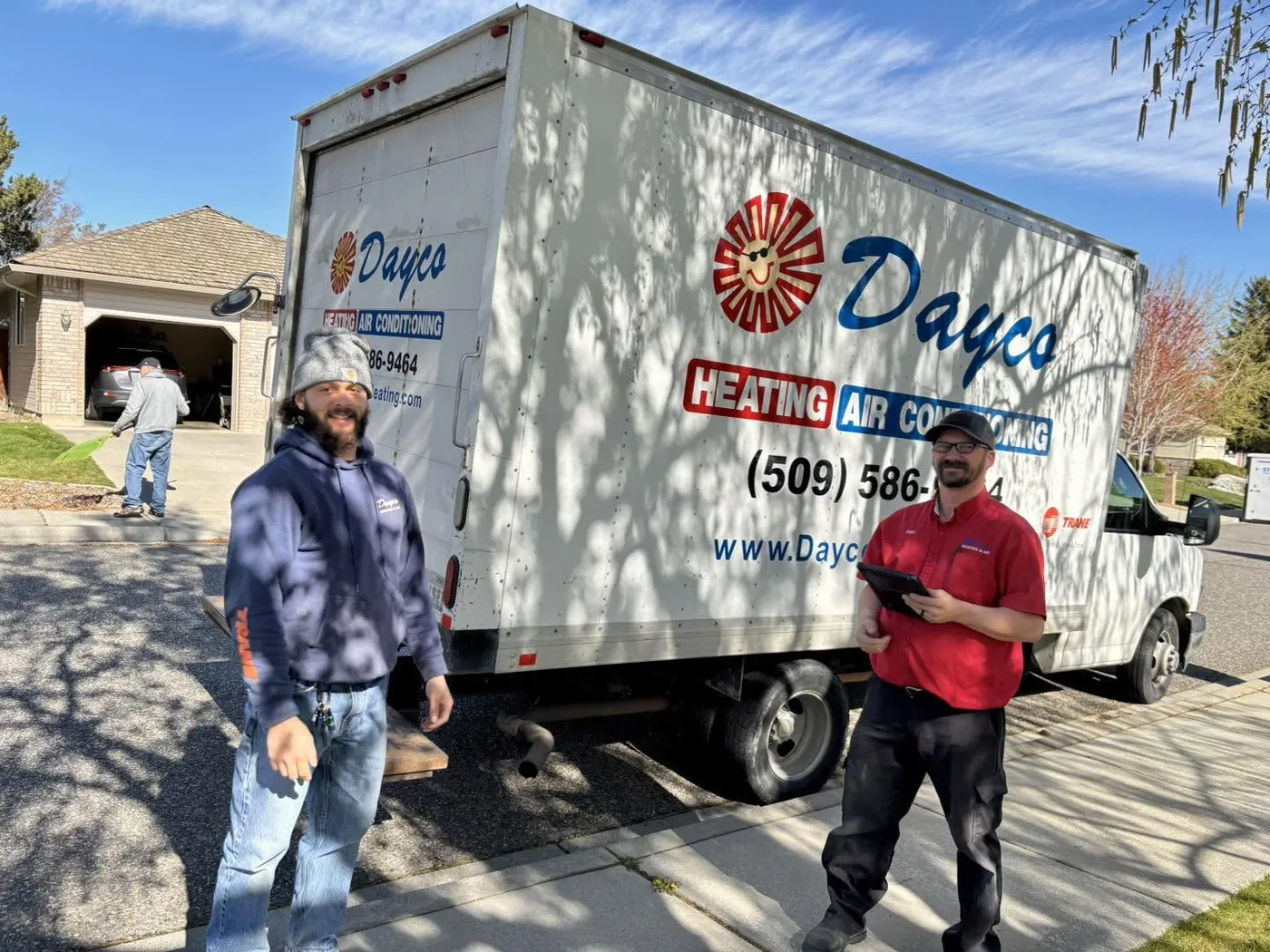 Two Dayco team members standing beside a Dayco box truck in a driveway